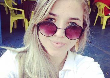 Letícia usava camisa baby look branca e calça jeans. Ela estava calçada com um tênis branco e azul