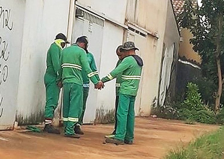 Foto de garis fazendo oração antes do trabalho em Valparaíso de Goiás | Foto: Talita Barbosa