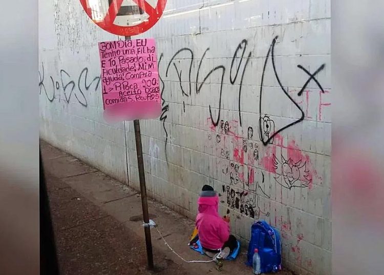 Mãe amarra filha em placa para vender pipoca em semáforo do DF | Foto: Israel Antonio Manoel Pereira