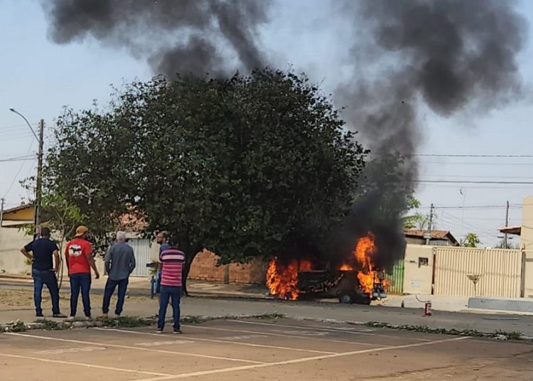Moradores observam kombi em chamas em frente a uma praça | Foto: Folha Z